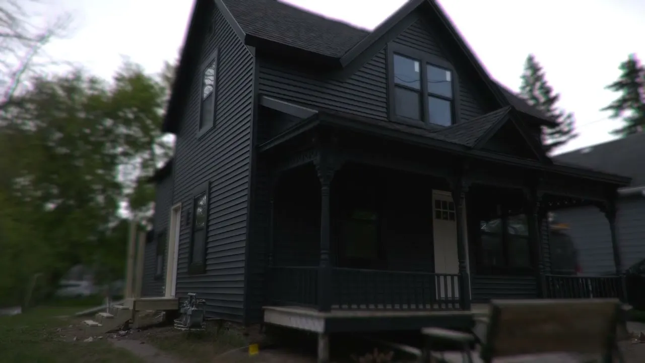 After: the rebuilt porch in black with the house in dark siding