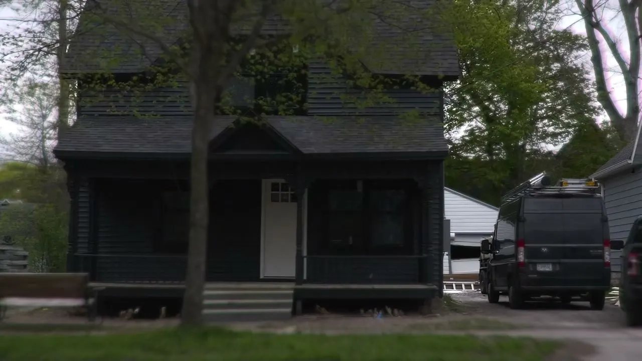 After: the restored Victorian from the street, dark siding and a black porch