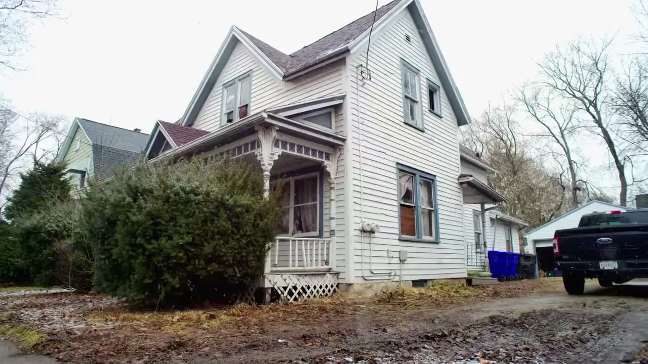 Before: the white Victorian with peeling paint, bare yard and boarded windows