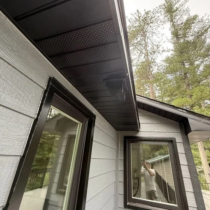 Two black-framed windows meeting at a corner in new siding