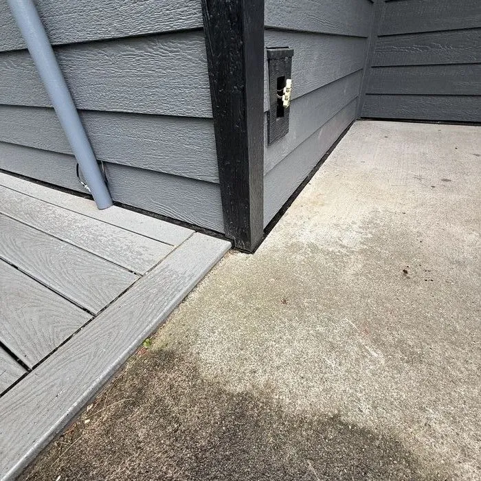 Siding corner with a black downspout and trim