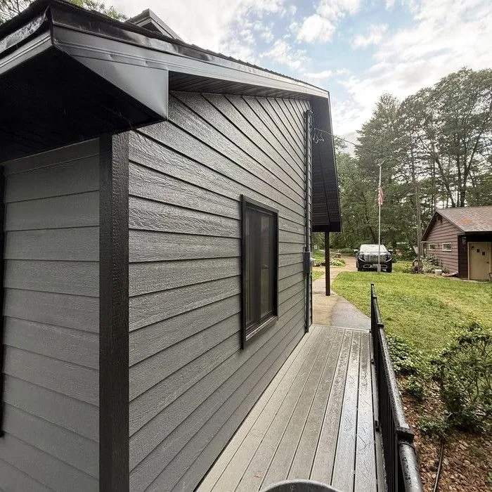 Long side wall of dark lap siding along the deck walkway