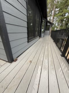 Deck walkway along the new grey siding and black-framed windows