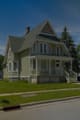 A Victorian house with a wraparound porch, seen from the street