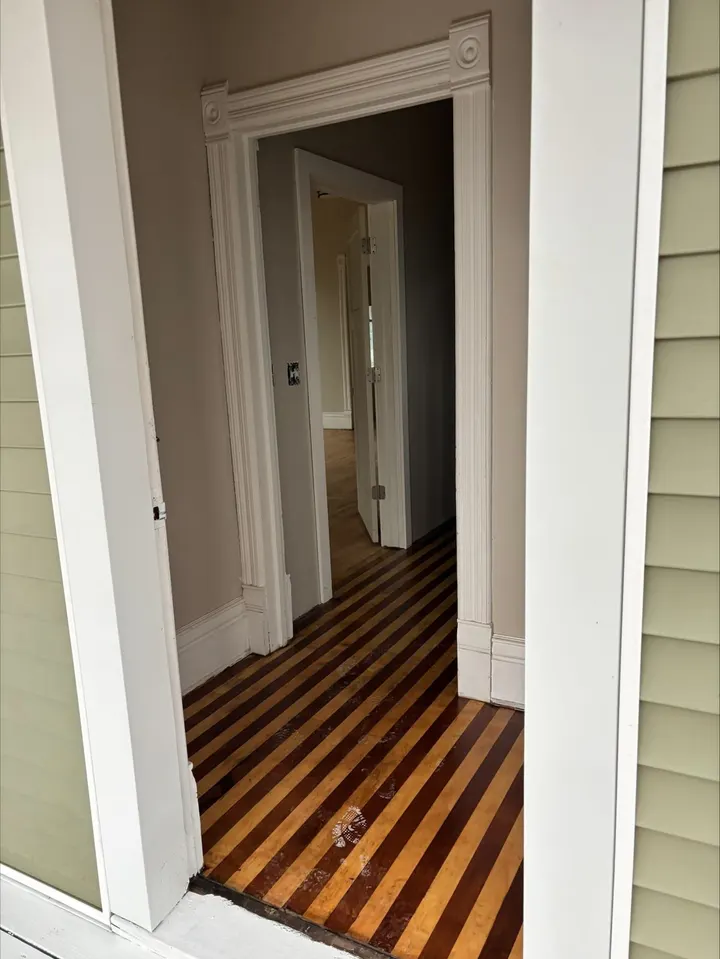 Refinished striped hardwood floor running down the hallway