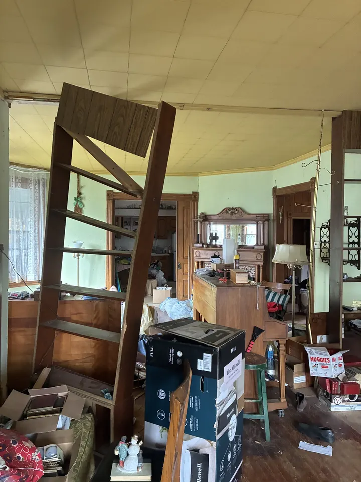 Before: the living room full of boxes and furniture with worn floors